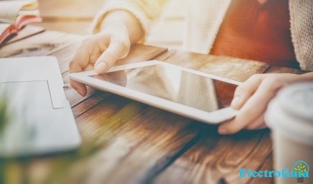 La mujer sostiene la tableta en la mano