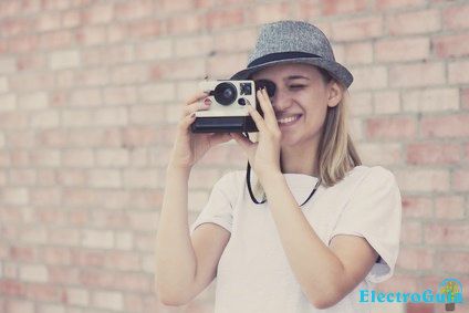 Señora fotografiando con una cámara instantánea